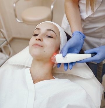 Cosmetologist use laser. Woman with cosmetologist. Lady in a beauty studio.